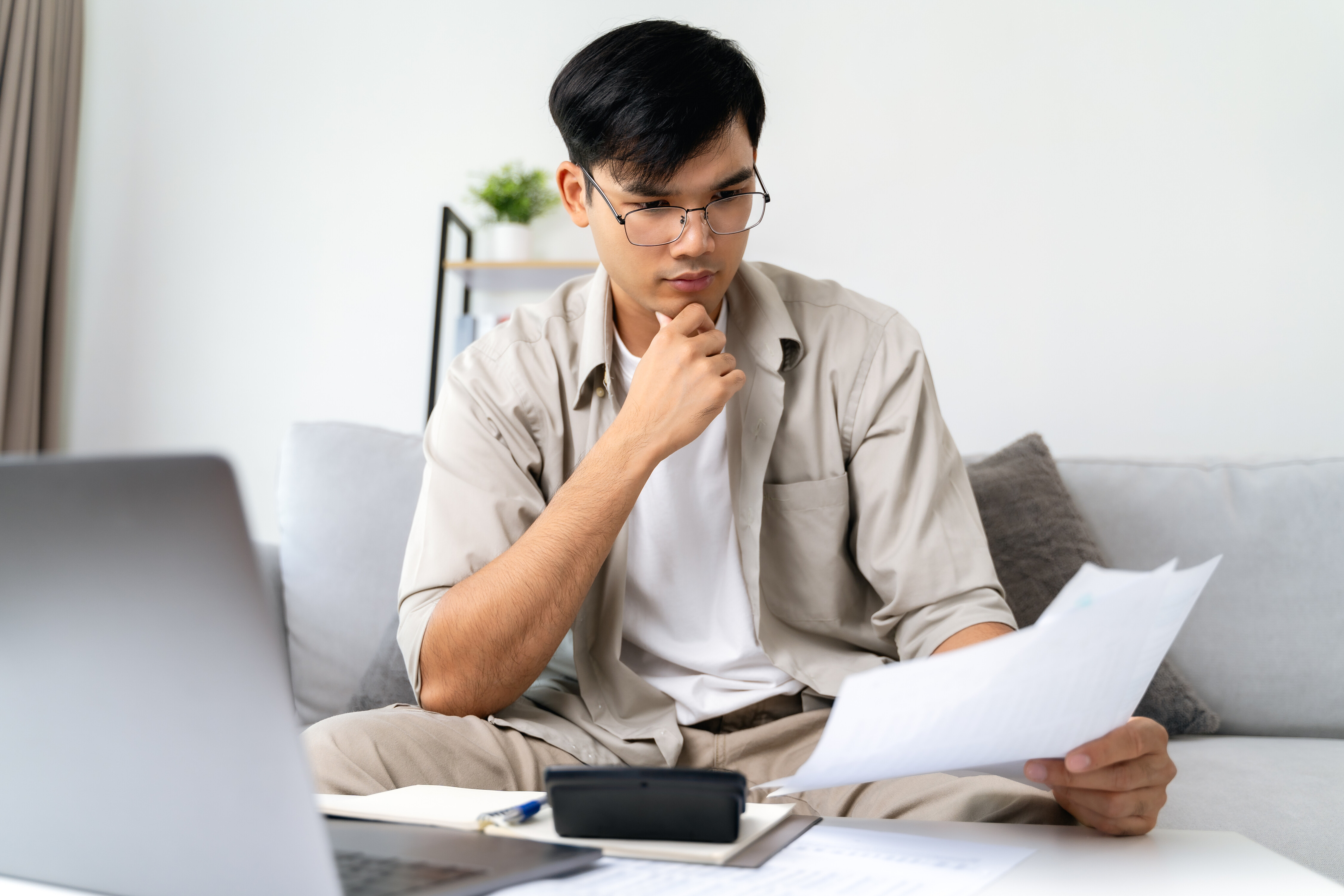 Ilustrasi pasangan muda sedang mengevaluasi polis asuransi dan perencanaan keuangan di awal tahun